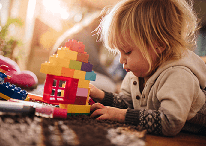 Toddler playing with toy bricks
